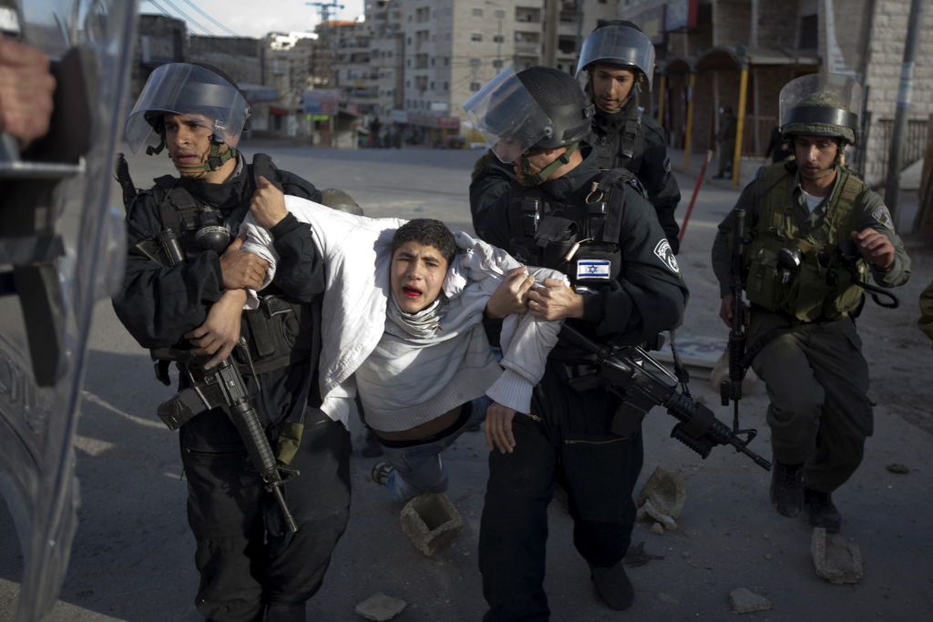 A Palestinian youth is arrested by Israeli border policemen on February 9, 2010. (Menahem Kahana—AFP/Getty Images)