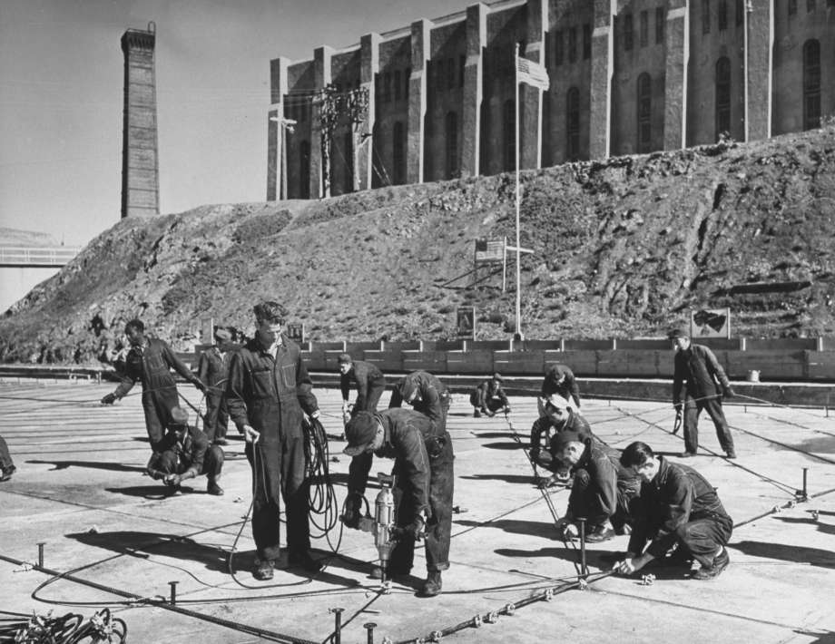 Prison inmates work on a large rope net to stop submarines.