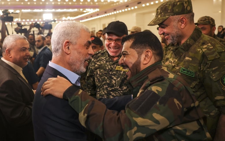 A politician greets soldiers in military fatigues.