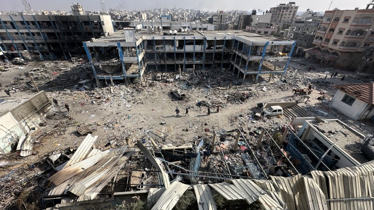 a multi-storey building with windows blown out surrounded by rubble