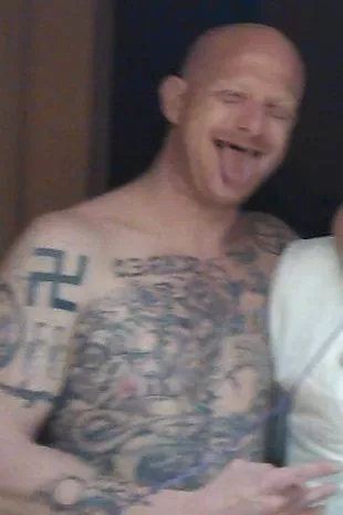 Photos of McDougal show him with a large swastika tattoo on his arm and shoulder