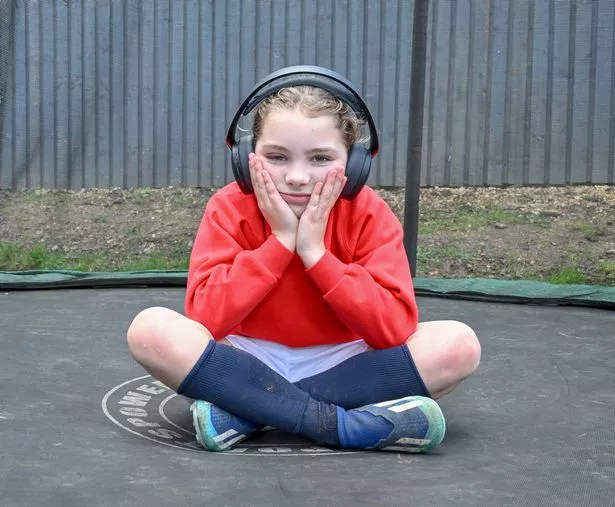 Lara Mills, 8, has to wear noise cancelling headphones to drown out the noise from the prison so she can sleep at night