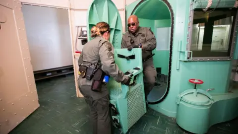 Getty Images Workers remove a chair from a gas chamber at San Quentin