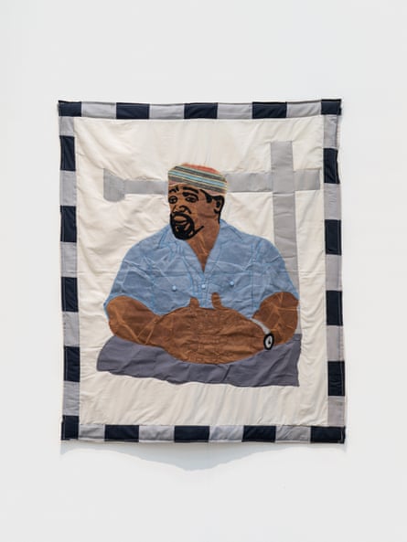 a quilt showing a portrait of a man with hands folded