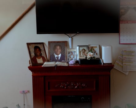 A cabinet beneath a wall-mounted flatscreen TV holds a collection of framed photographs.