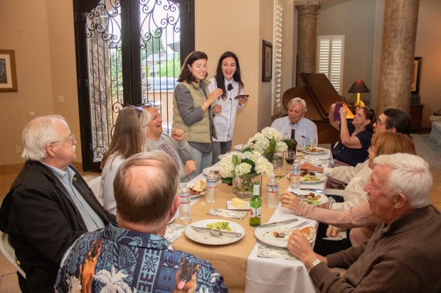 Olena Balzhyk (standing, right) delivers a speech translated by Uliana Pashynna thanking Woodland Rotary Club members and highlighting the 