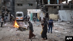 Palestinians look at the rubble of a family house that was hit overnight in Israeli bombardment in the Tal al-Sultan neighborhood of Rafah in southern Gaza, May 20, 2024.