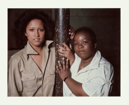 Two women on either side of a narrow pillar