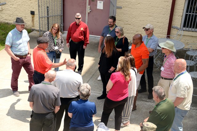 Retired 1st Sgt. Michael Jones leads a tour group through the grounds of the Old U.S. Disciplinary Barracks May 21, 2024, starting outside 12th Brick Grille at Fort Leavenworth, Kansas. Photo by Prudence Siebert/Fort Leavenworth Lamp