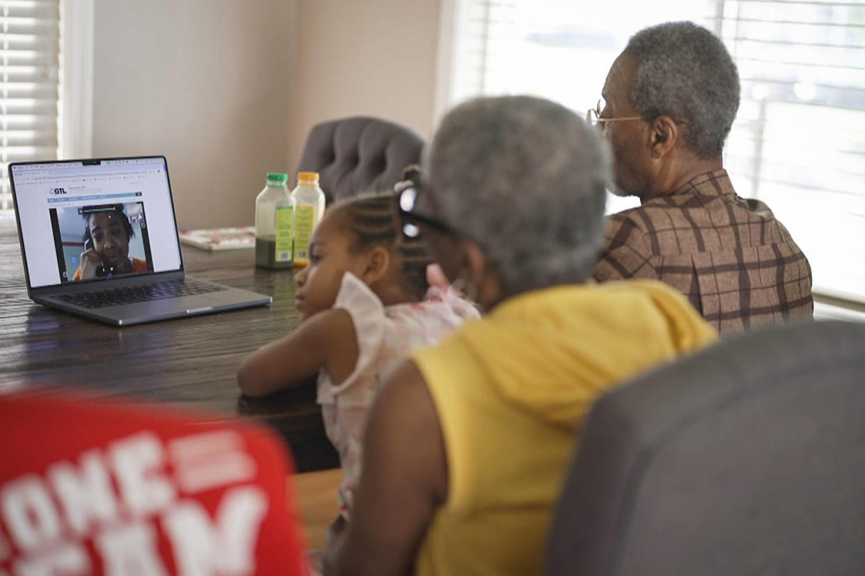 Reekila Harris-Dudley, seen on a laptop, speaks during a video call to her family members in their dining room (NBC News)