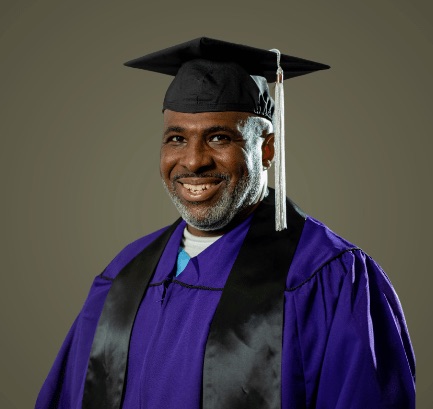 Michael Broadway poses for his Northwestern University graduation photo in cap and gown.