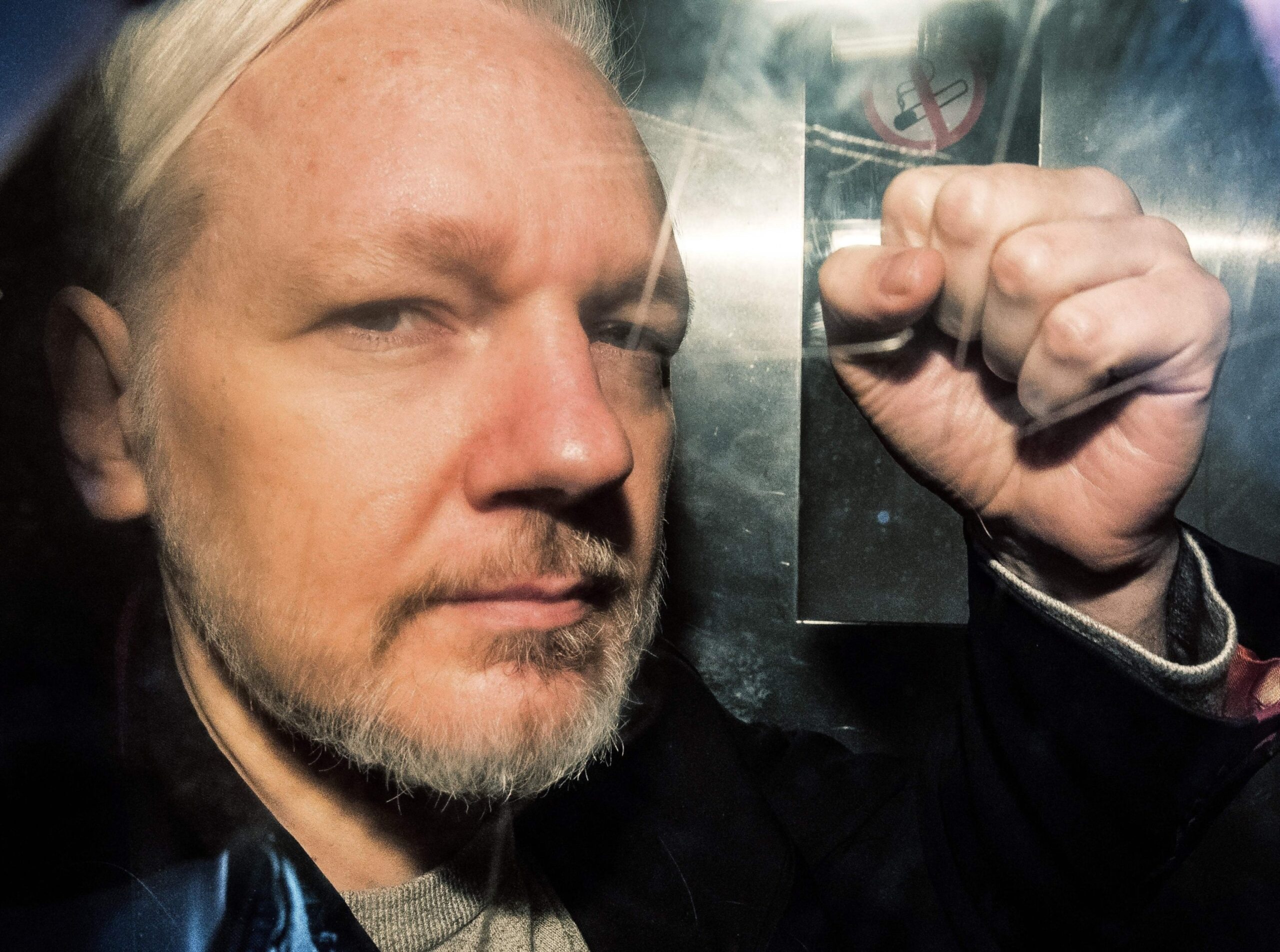 PHOTO: WikiLeaks founder Julian Assange gestures from the window of a prison van as he is driven into Southwark Crown Court in London on May 1, 2019.