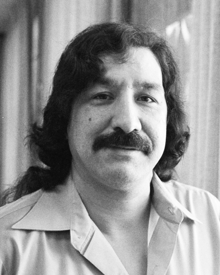 Black and white portrait of Leonard Peltier smiling