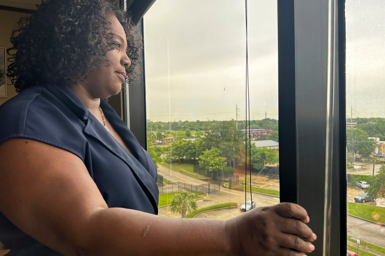 Delisha Boyd looks out an upper-story window in Louisiana.