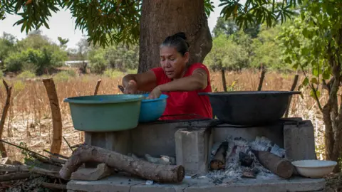 Natalia Alberto Marcela Alvarado prepares food outside her house