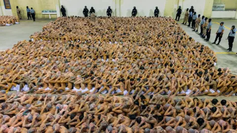 Reuters A photo provided by El Salvador's government shows hundreds of inmates sitting tightly packed at the Cecot prison