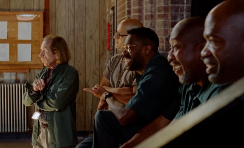 a group of prisoners smile while watching a rehersal