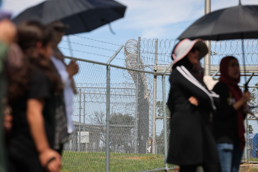 Barbed wire surrounds FMC Carswell where protesters stand to protest for Aafia Siddiqui on Sunday, Sept. 22, 2024, in Fort Worth.