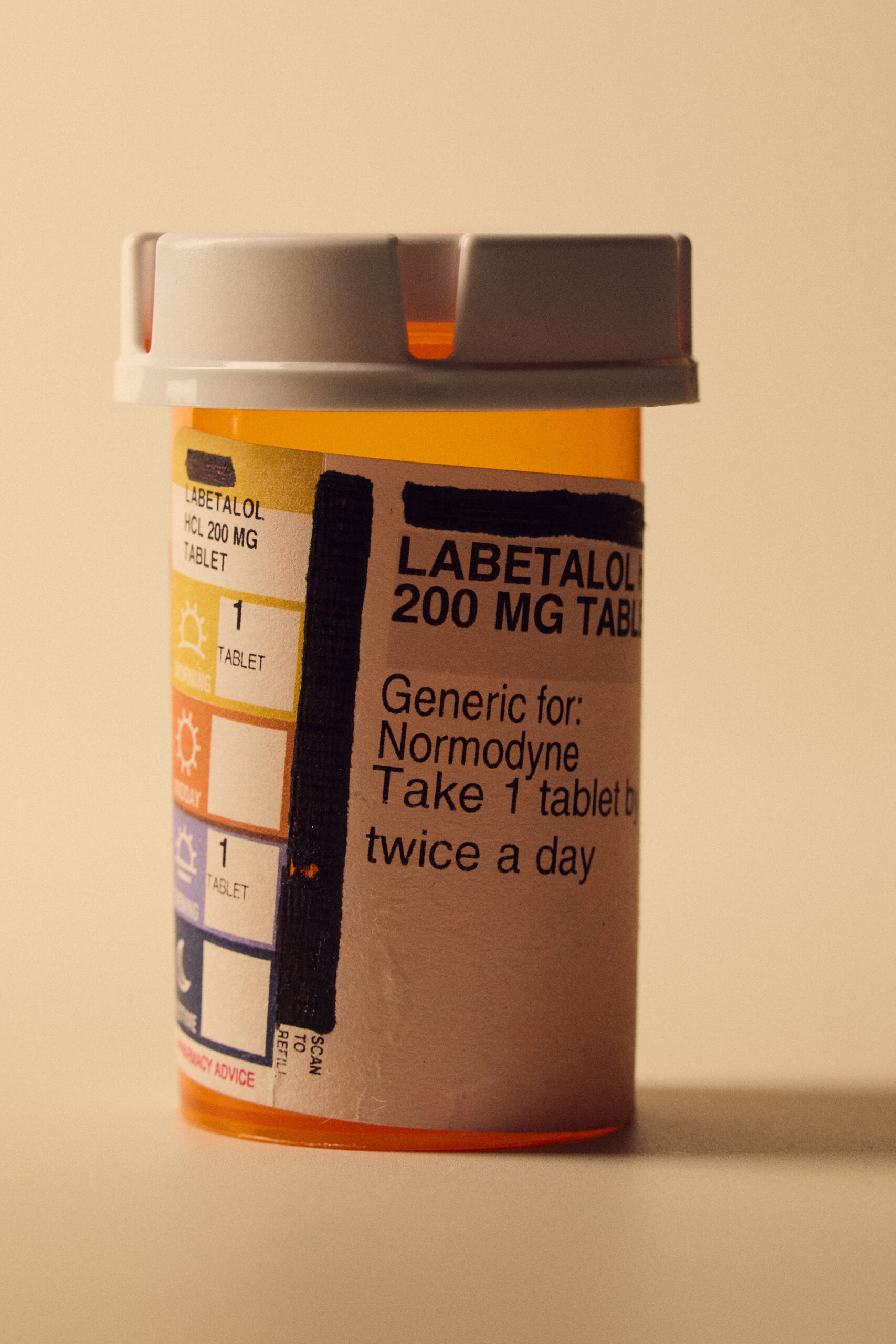 A studio shot of an orange pill bottle with the word 'labetalol' on the label.