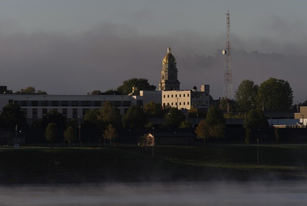 A light fog floats around the Cabell County Courthouse at sunrise in Huntington, W. Va. across the Ohio River from Chesapeake, Ohio, Oct. 10, 2024. (AP Photo/Carolyn Kaster)