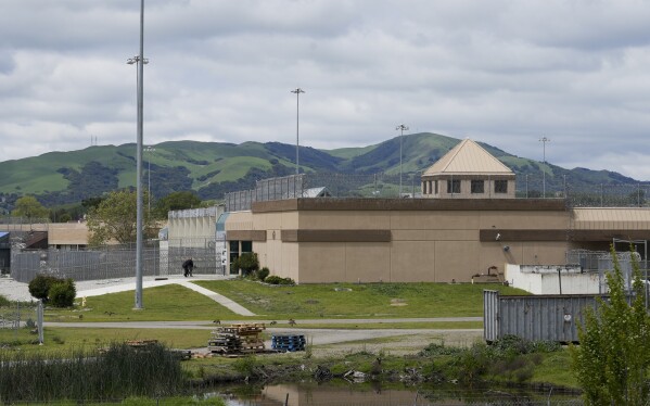 FILE - Two men walk into the Federal Correctional Institution in Dublin, Calif., Monday, April 15, 2024. (AP Photo/Terry Chea, File)