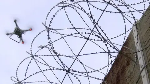 BBC Drone flying next to a barbed wire fence