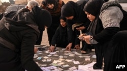 People search documents for any information on their missing relatives, at the Mazzeh military airport, outside Damascus, Syria, Dec. 12, 2024.