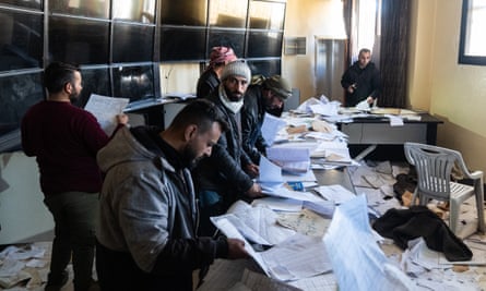 A group of men look through documents in a prison office