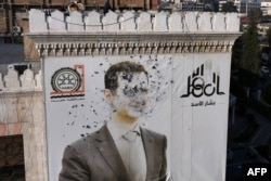 This aerial picture shows a bullet-riddled portrait of Syrian President Bashar al-Assad adorning Hama's municipality building after it was defaced following the capture of the city by anti-government fighters, Dec. 6, 2024.