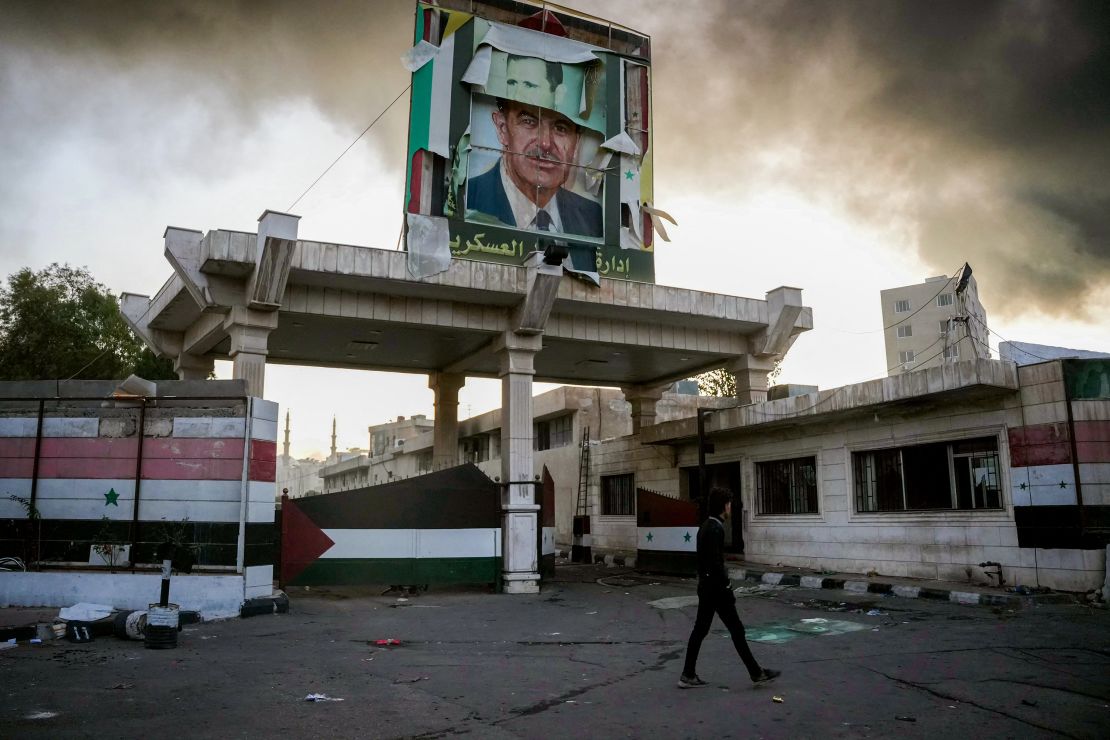 TOPSHOT - A defaced portrait of late Syrian president Hafez al-Assad stands above a ransacked government security facility, in Damascus, on December 8, 2024. Islamist-led rebels declared on December 8, that they have taken the Syrian capital in a lightning offensive, sending President Bashar al-Assad fleeing and ending five decades of Baath rule in Syria. (Photo by Rami al SAYED / AFP) (Photo by RAMI AL SAYED/AFP via Getty Images)