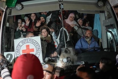 Palestinian female prisoners wave from inside a bus as they arrive in the West Bank city of Beitunia, early Monday, Jan. 20, 2025. 