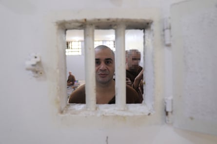 Mustafa Hajj-Obeid looks out from behind the bars in the window of a cell door