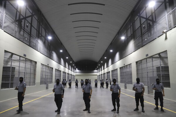 Prison guards stand outside holding cells during a media tour of the Terrorism Confinement Center, or CECOT, in Tecoluca, El Salvador, Feb. 2, 2023. (AP Photo/Salvador Melendez, File)