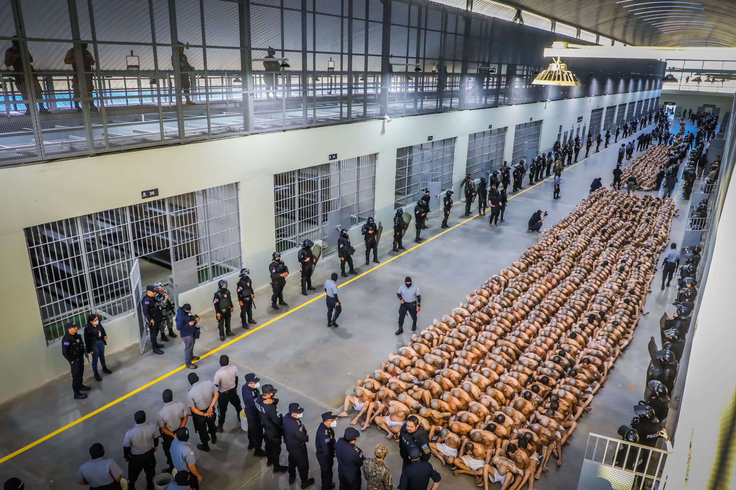 Police officers in riot gear guarding the arrival of inmates belonging to the MS-13 and 18 gangs at the CECOT prison