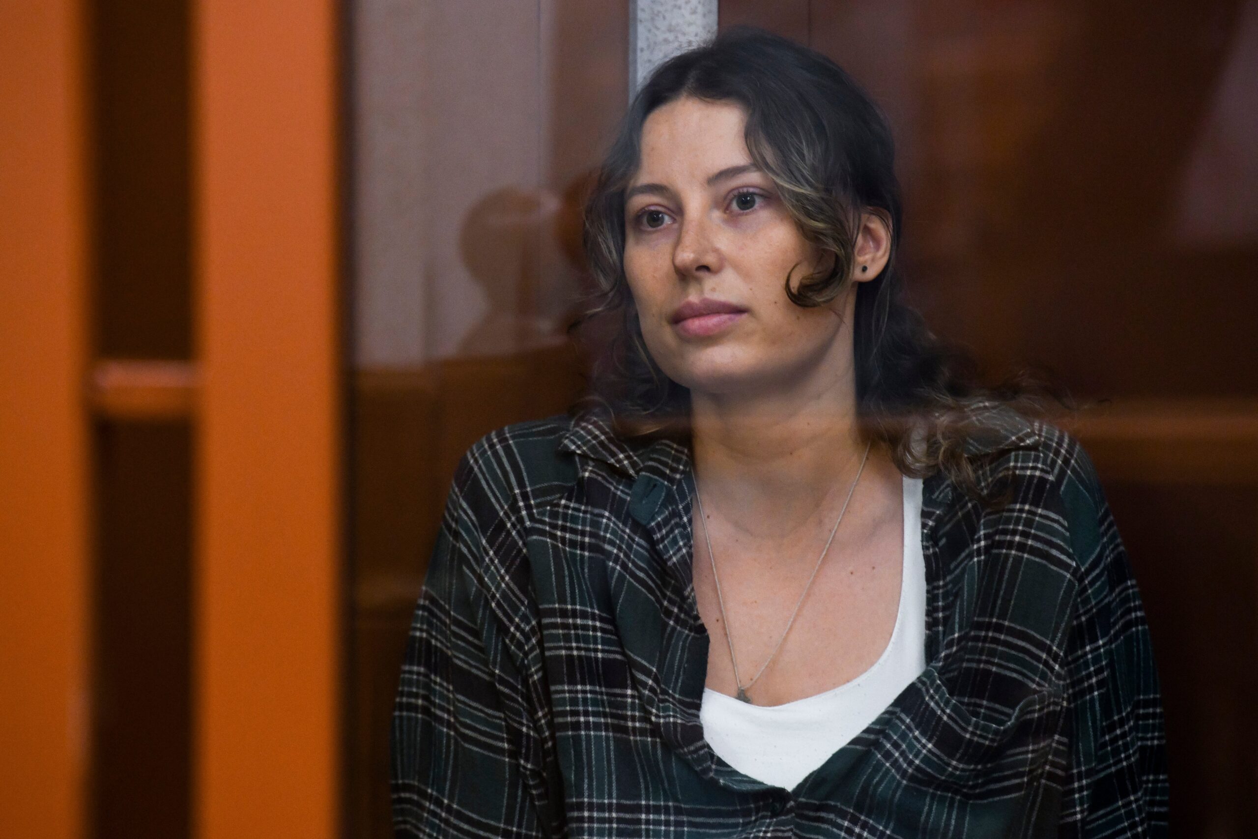 Former ballerina Ksenia Karelina, also known by the last name of Khavana, sits in a defendant’s cage in a court in Yekaterinburg after being accused of collecting money for Ukraine’s military