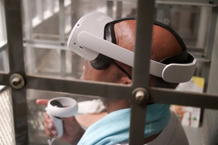 a person wearing a white VR headset and holding a gadget looks up