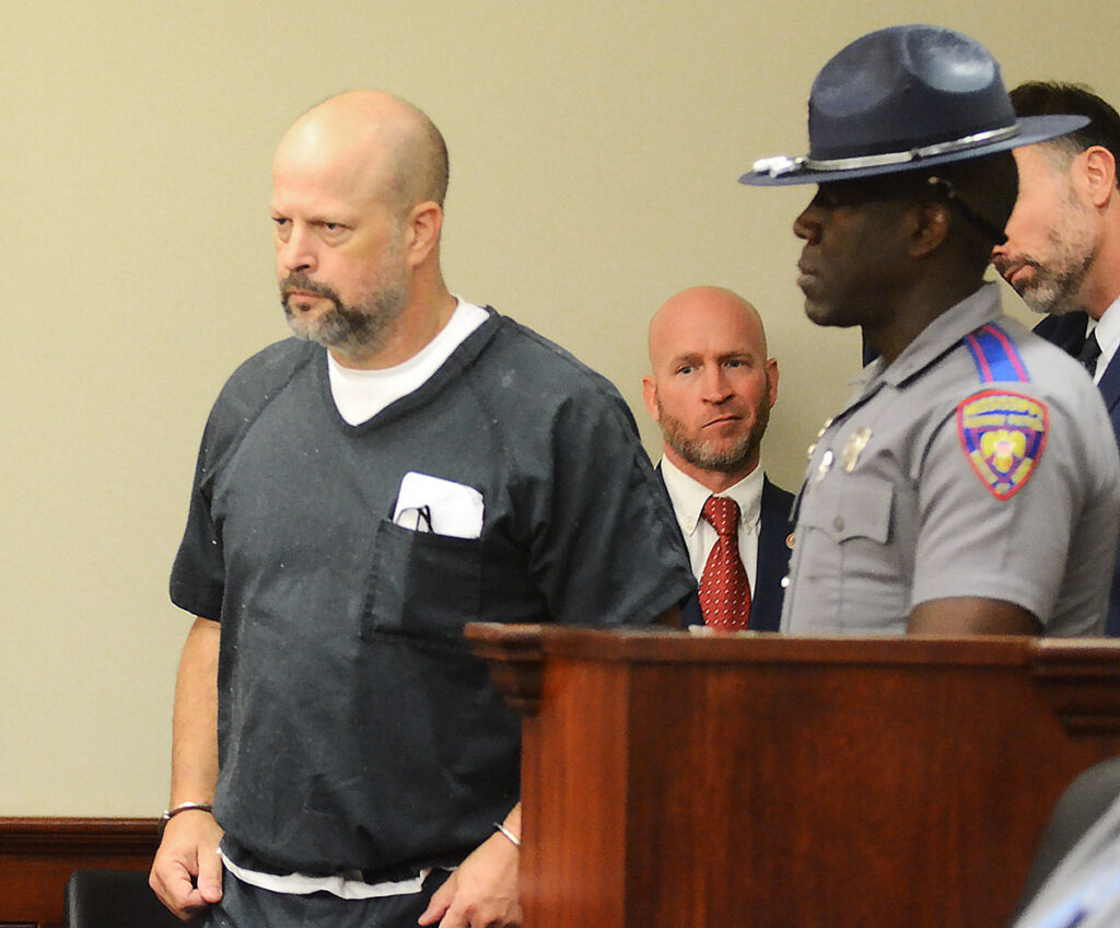 Former Rankin County law enforcement officer Brett McAlpin, enters Rankin County Circuit Court. He is wearing a prison uniform and handcuffs as a deputy escorts him.