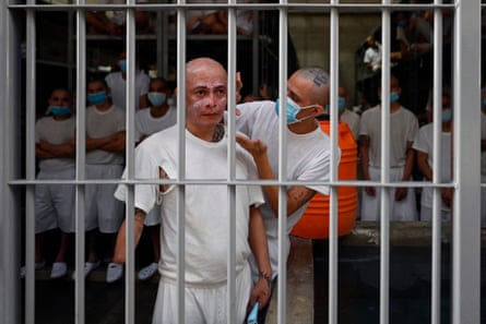 An inmate puts cream on a fellow inmate’s face in a cell 