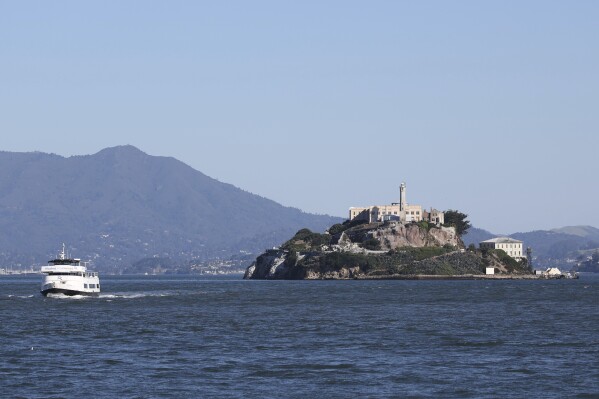 A tour boat is skippered past Alcatraz Island Monday, May 5, 2025, in San Francisco. (AP Photo/Jed Jacobsohn)