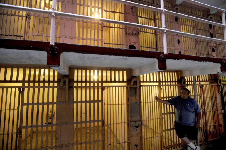 A visitor to Alcatraz Island's former federal prison leans against a B Block cell in the San Francisco Bay