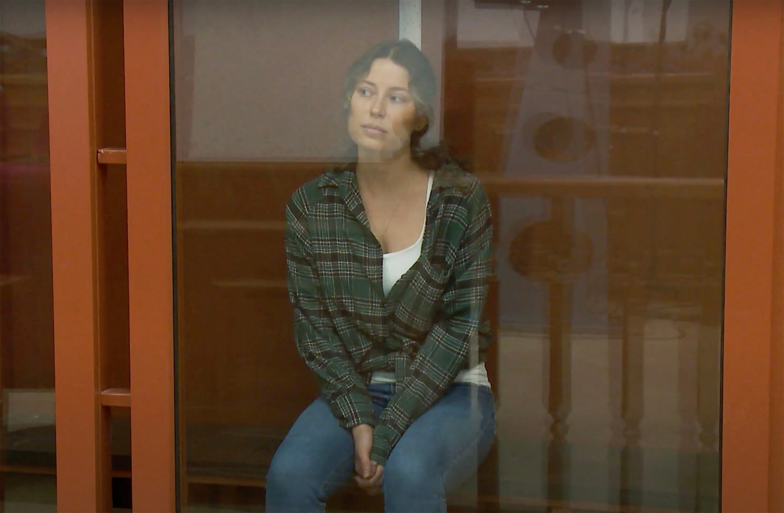 Karelina pictured in a glass cage while attending court last year. She was arrested for donating to a charity that sends aid to Ukraine
