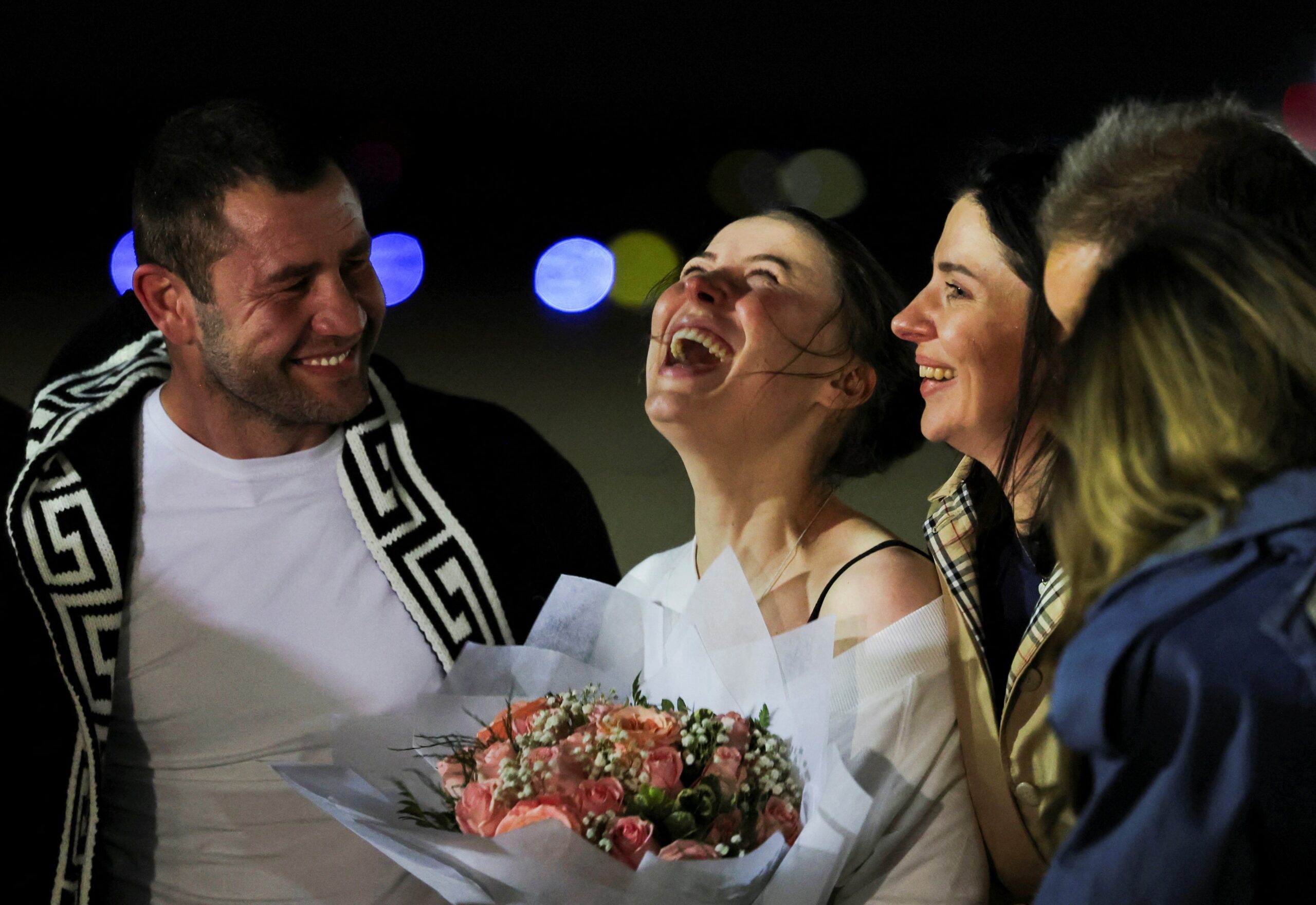 Ksenia Karelina (center) celebrates after she was returned to the U.S. from Russian prison last month