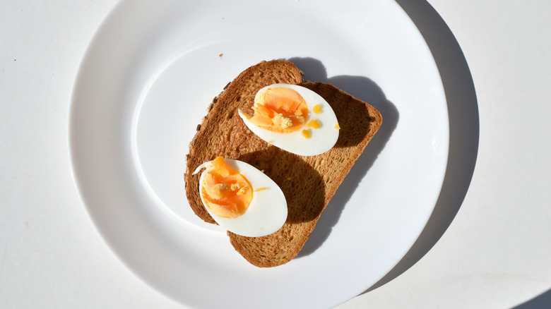 Plate of boiled egg cut in two on toast
