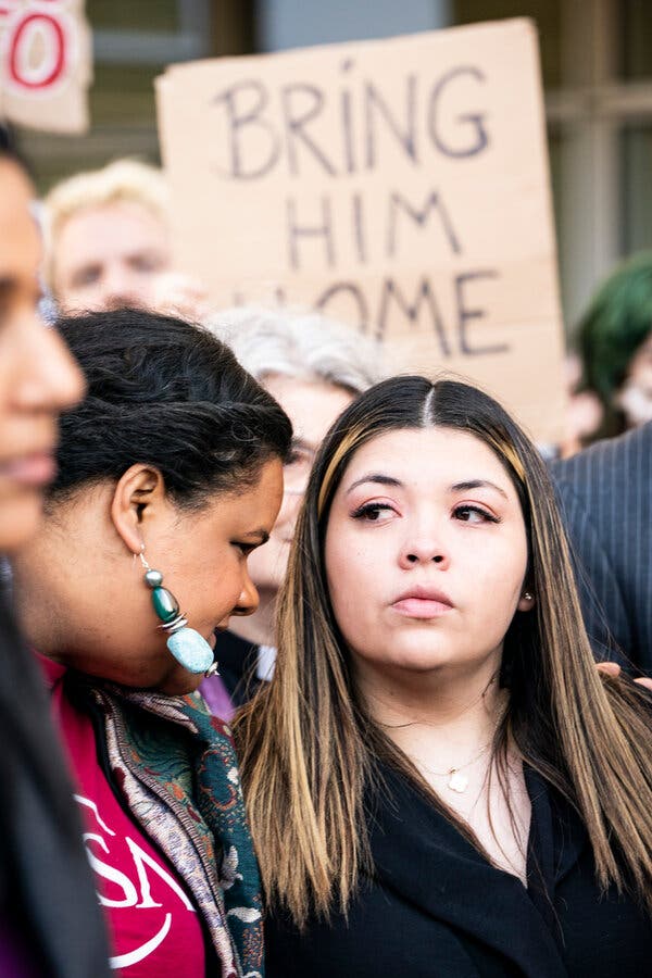 Jennifer Vasquez Sura listening to a person talking to her at a news conference outside of a courthouse.